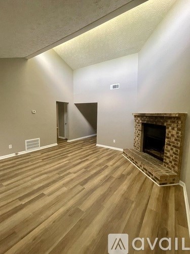 A room with a fireplace and wooden flooring.