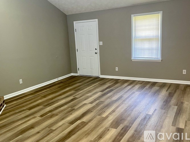 A room with a white door and a window with blinds.