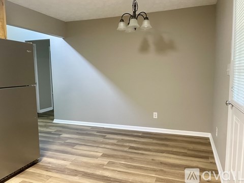 A kitchen with a refrigerator and a chandelier.