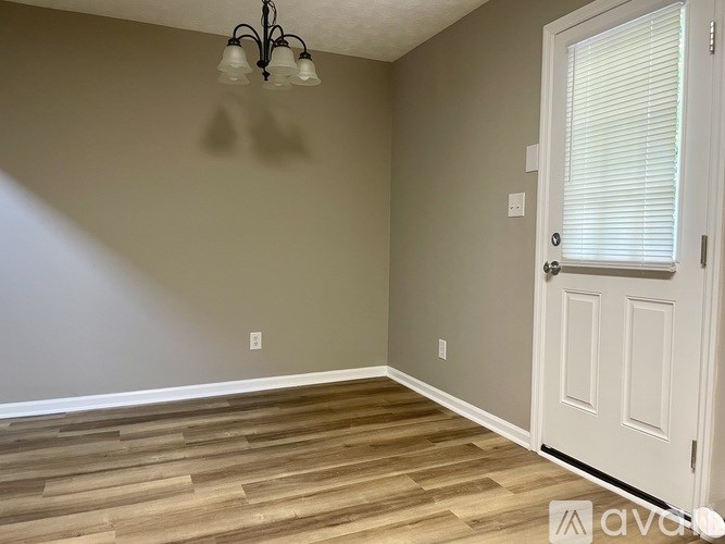 A room with wooden flooring and a white door.