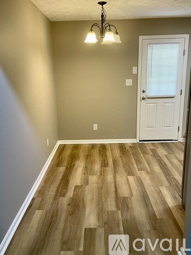 A room with wooden flooring and a white door.