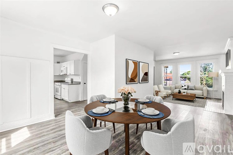 A modern dining room with a round table and white chairs.