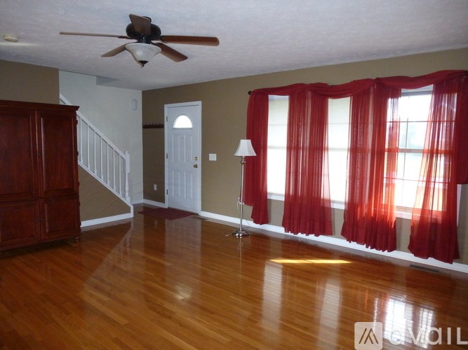 A room with a wooden floor and a ceiling fan.