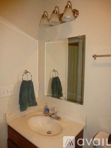 A bathroom with a sink, mirror, and towel rack.