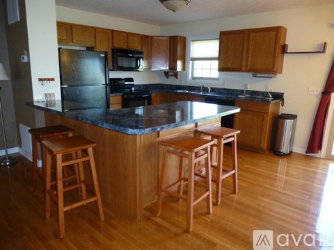 A kitchen with wooden cabinets and a black countertop.
