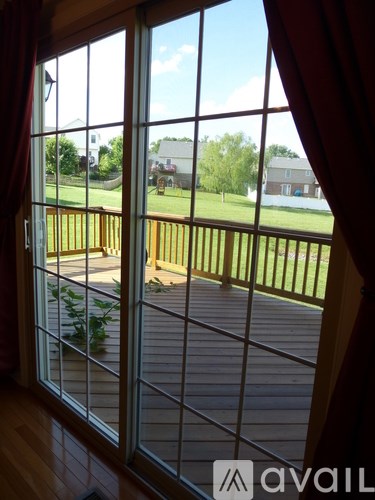 A view from inside a house looking out through a window to a deck.