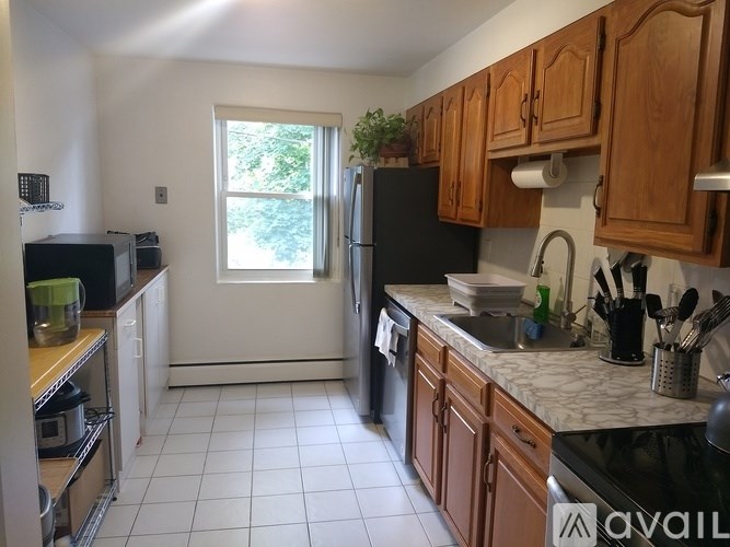 A kitchen with wooden cabinets and a black fridge.