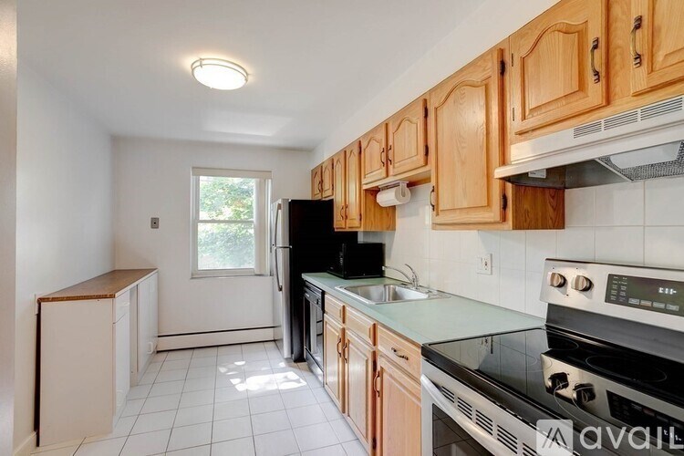 A kitchen with wooden cabinets and a black stove top oven.