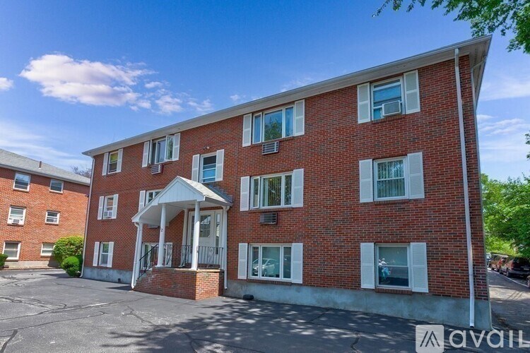 A red brick building with a white entrance and windows.