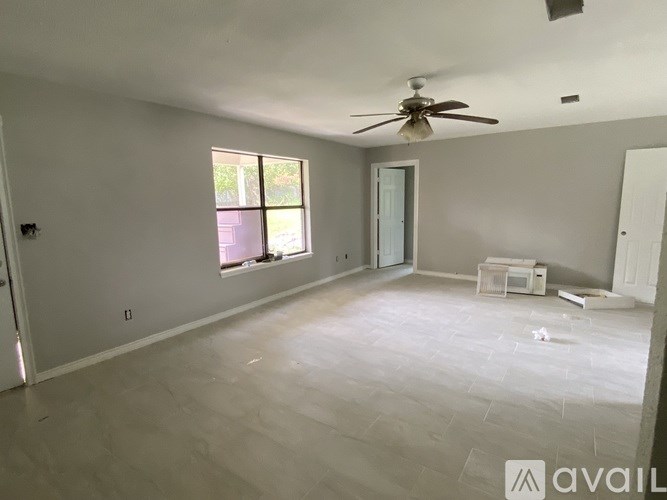 A room with a ceiling fan and a window.