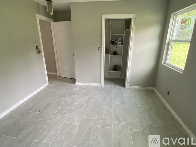 A room with a grey tile floor and a white door.