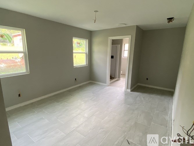 A room with a tiled floor and a door leading to another room.