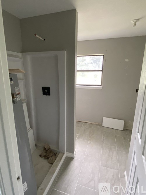 A bathroom with a toilet and a window.