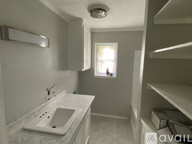 A bathroom with a marble countertop and a window.