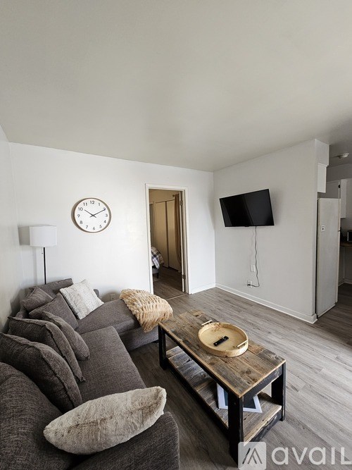 A living room with a grey couch and a wooden coffee table.
