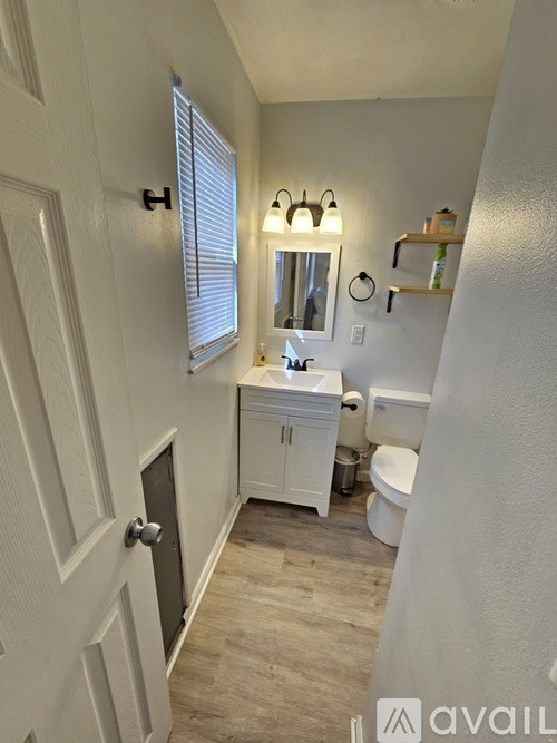 A bathroom with a white cabinet and a mirror above the sink.