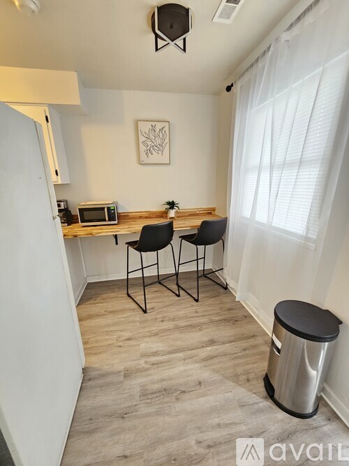 A small kitchen with a microwave and a dining table with two chairs.