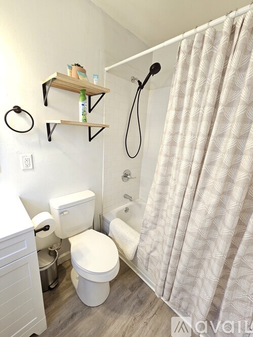 A white toilet with a white curtain in the bathroom.