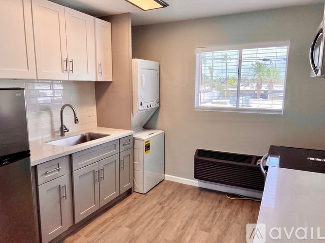 A kitchen with a black fridge and a black dishwasher.