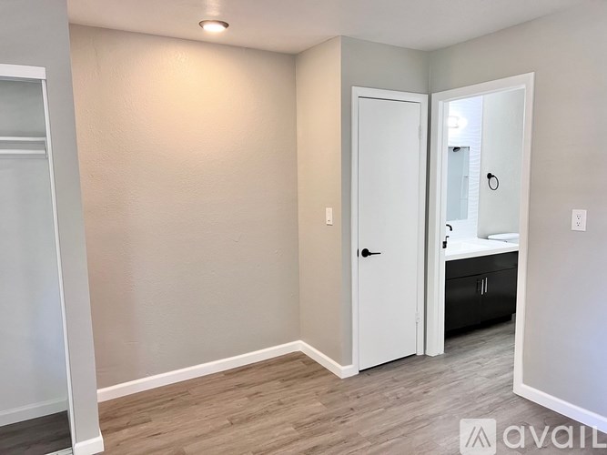 A room with a white door and a mirror on the wall.