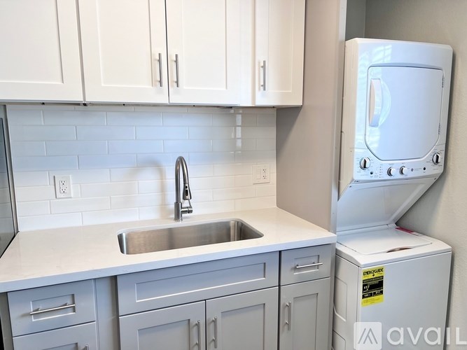 A kitchen with a white sink and a white dishwasher.
