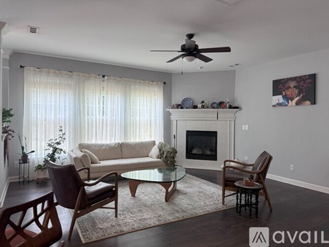 A living room with a fireplace and a painting on the wall.