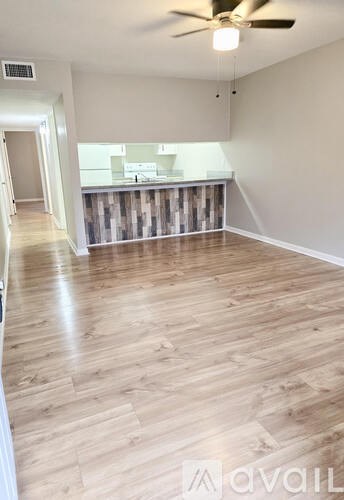 A room with wooden flooring and a ceiling fan.
