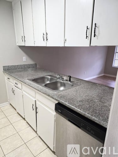 A kitchen with a granite countertop and white cabinets.