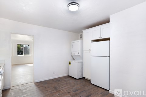 A kitchen with white appliances and cabinets is available for rent.