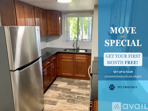 A kitchen with a refrigerator, sink, and wooden cabinets is on display with an advertisement for a free first month.