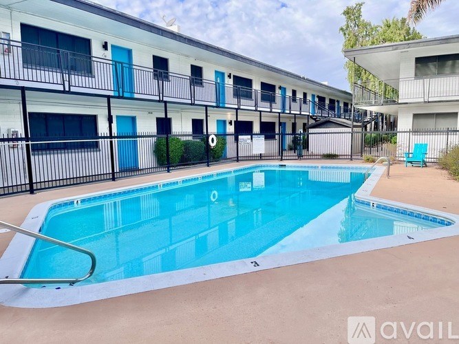 A swimming pool in front of a building with blue doors.