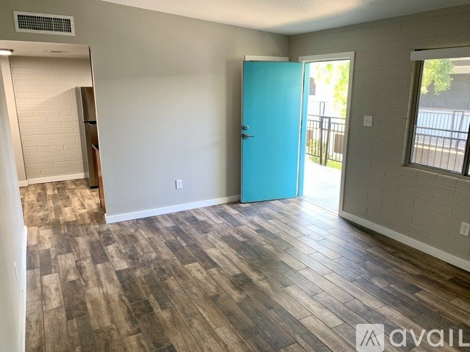 A room with a blue door and wooden flooring.