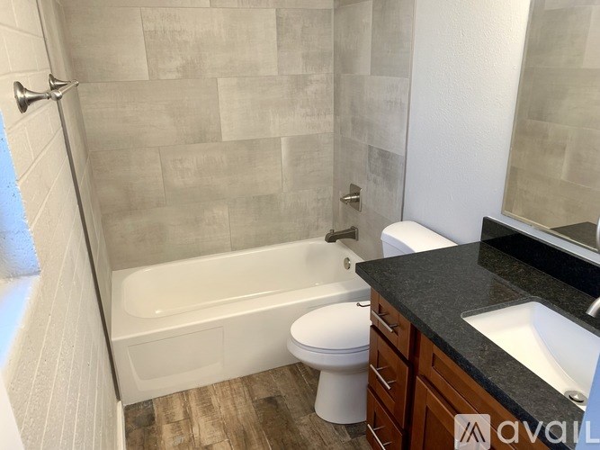A bathroom with a white tub, toilet, and sink.