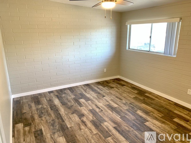 A room with wooden flooring and a window.