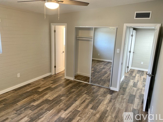 A room with wood flooring and a ceiling fan.