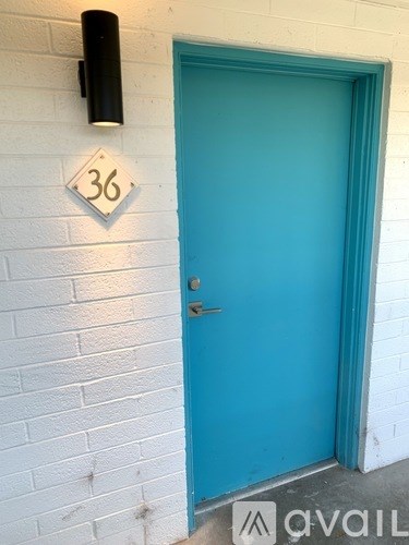 A blue door with a number 36 on the wall above it.