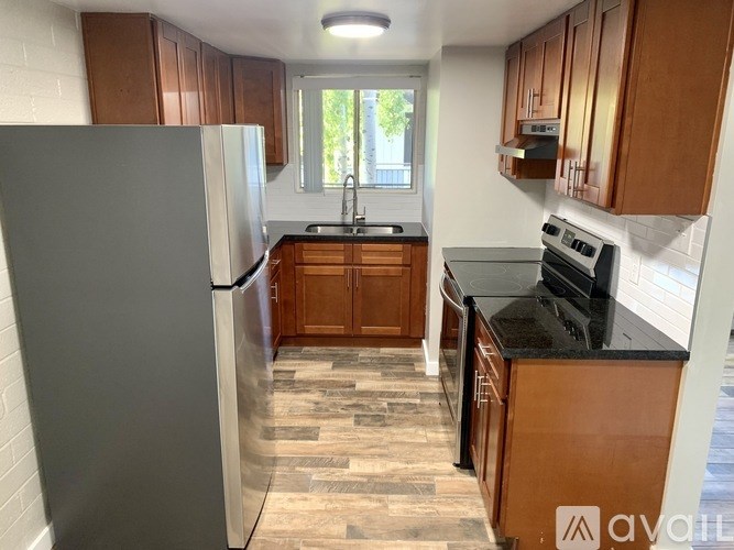 A kitchen with wooden cabinets and a black countertop.