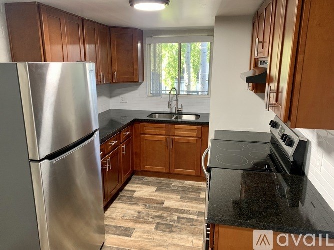 A kitchen with wooden cabinets and a stainless steel refrigerator.