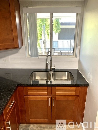 A kitchen with wooden cabinets and a black countertop.