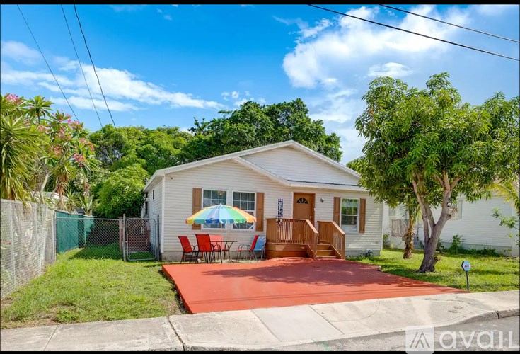 A house with a red patio and a blue umbrella.