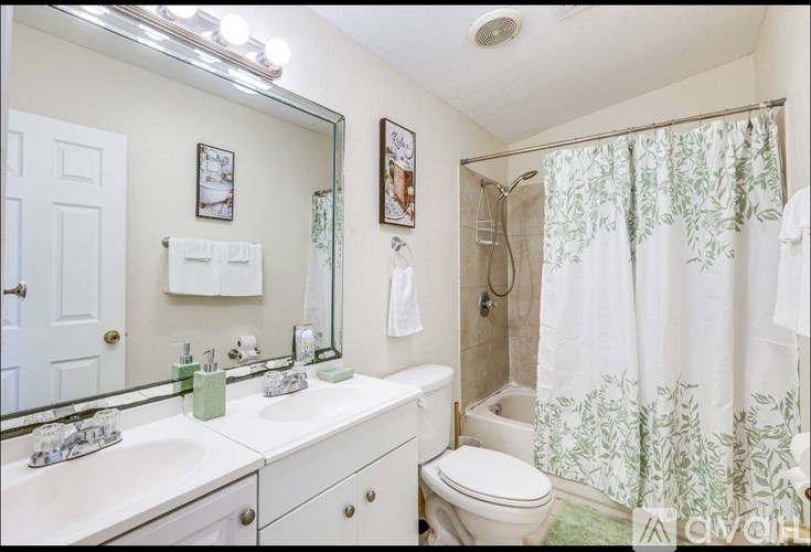 A white bathroom with a toilet, sink, and shower.