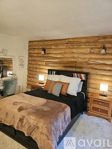A bedroom with a wooden headboard and a bed with a brown blanket.