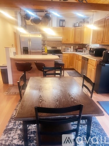 A kitchen with a table and chairs in the foreground.