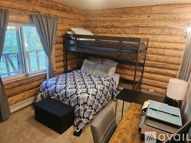 A bedroom with a bunk bed and a window with curtains.