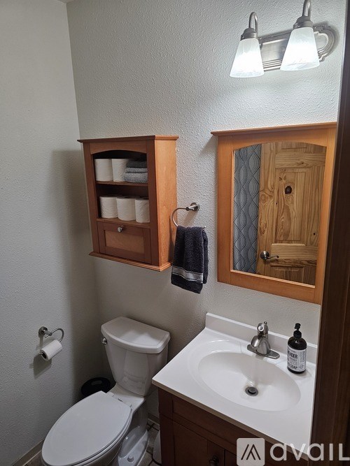 A bathroom with a toilet, sink, and medicine cabinet.