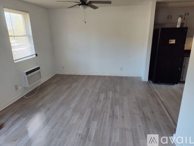 A room with a ceiling fan and a window with blinds.