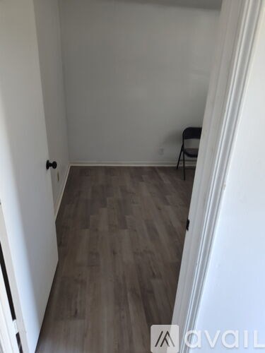 A room with a wooden floor and a chair.