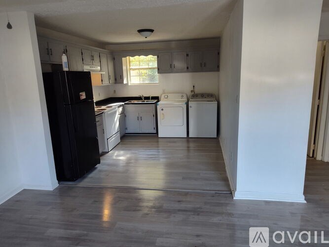A kitchen with black appliances and white cabinets.