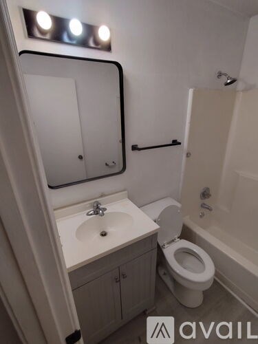 A bathroom with a sink, toilet, and mirror.
