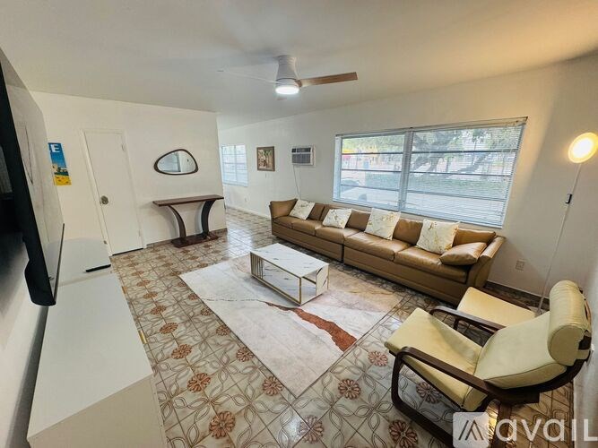 A living room with a couch, chair, and rug.